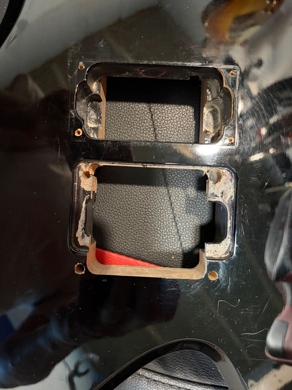 Empty pickup cavities on a black electric guitar body.