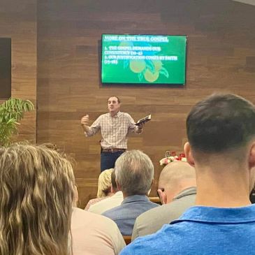 Speaker presenting religious content to an attentive audience in a church setting.