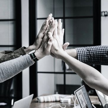 A group of hands all giving each other a high-five at the same time.