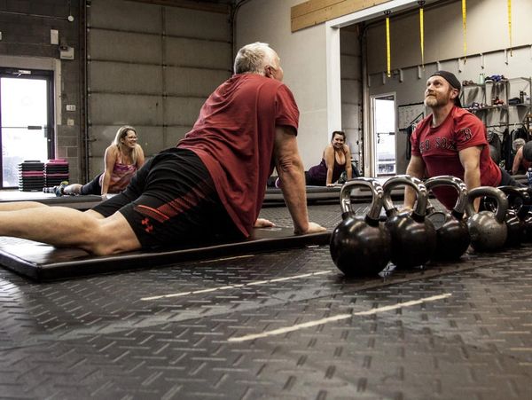 Man stretching on gym floor.