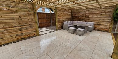 Wooden pergola with porcelain paving and outdoor seating.