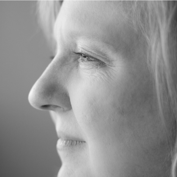 Close-up black and white profile of a woman's face, showing thoughtful expression.