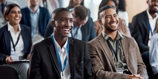 Diverse business professionals smiling and enjoying a conference.