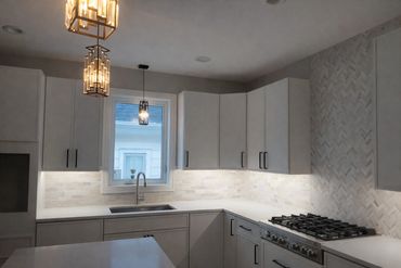 Kitchen improvement featuring tile backsplash installation and updated cabinets.