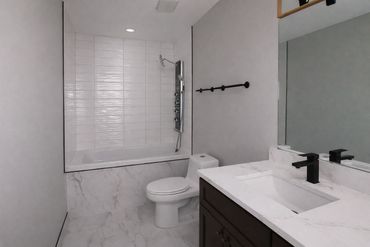 Walk-in shower tile installation with waterproofing and porcelain bathroom flooring.