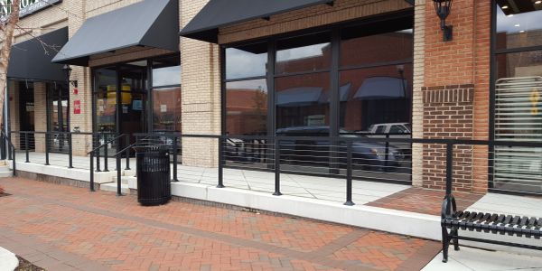 Storefronts with brick and sidewalk seating area.