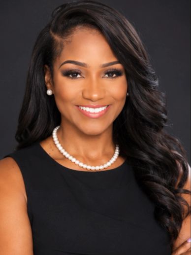 Smiling woman with pearl necklace and earrings.