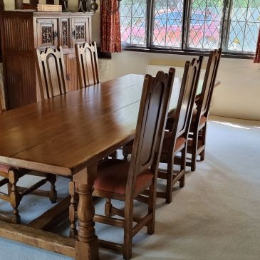 Wooden dining table with six chairs in a cozy room.