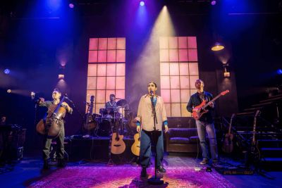 Band performing on stage with colorful lights.