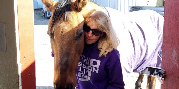 A woman taking picture with horse