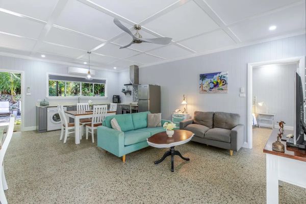 Bright, open living and kitchen area with modern furnishings and garden views.