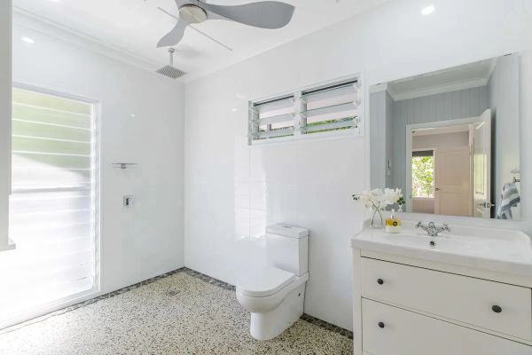 Bright and modern bathroom with terrazzo floor and large mirror.