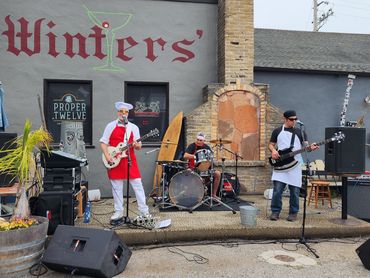 Outdoor band performance with members dressed as chefs at Winter's bar.