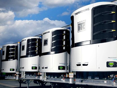 A row of refrigerated truck units under a blue sky.