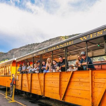 Group of people enjoying a scenic train ride on the Rio Grande Western Railway.