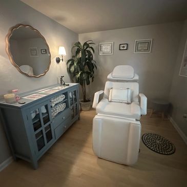 Cozy spa room with a comfortable white chair and calming decor.