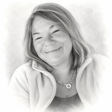 Black and white portrait of a smiling woman with a heart necklace.