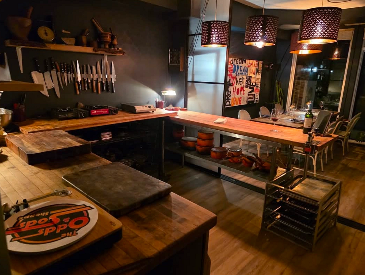 Cozy kitchen with wooden countertops, hanging knives, and warm lighting.