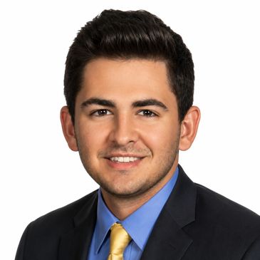 Professional headshot of a young man in business attire.