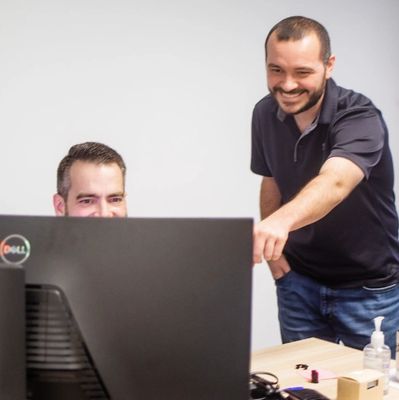 Eric Nichols and Josh Pivato collaborating on a business intelligence project at a computer.