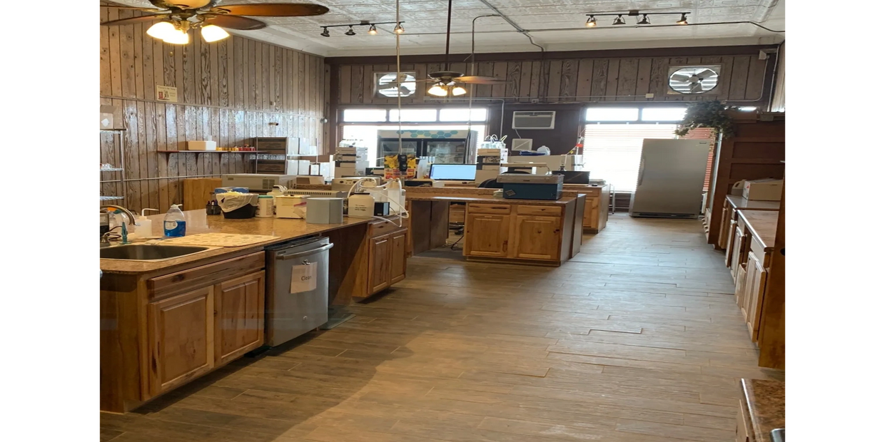 Spacious kitchen with wooden cabinets and ceiling fans.