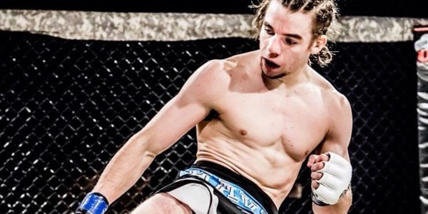 MMA fighter delivering a kick in the cage.