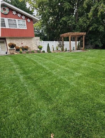 Lawn with long straight mowing lines from a fresh cut maintenance service.