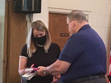 Pastor Larry presents Bibles to 
recently baptized new members.