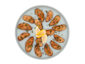 Grilled salmon pieces arranged in a circle with lemon wedges.