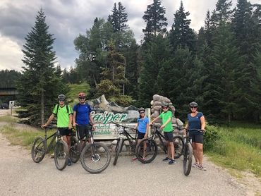 Family in front of old Jasper welcome sign with rental bikes