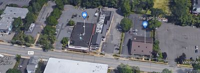 Aerial view of CVS and The UPS Store with parking lots and nearby buildings.
