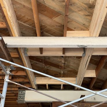 Construction site showing wooden beams and metal scaffolding.