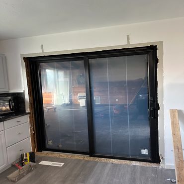 Newly installed sliding glass door in a kitchen under renovation.