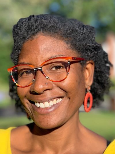 African American woman wearing glasses smiling in the sunshine