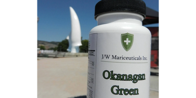 Bottle of Okanagan Green Canadian Hemp Oil capsules outdoors.