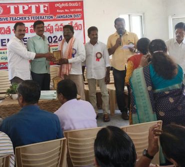 A group of men at a TPTF event, one receiving a plaque.
