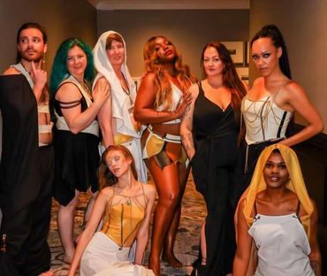 A diverse group of fashionably dressed individuals posing confidently indoors.