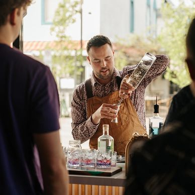 Un barman verse un verre devant des clients.