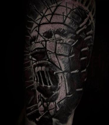 Dark, eerie tattoo of a face with nails screaming.