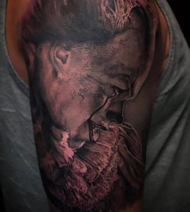 Black and grayscale tattoo, a realistic Pennywise side face profile, horror scene.