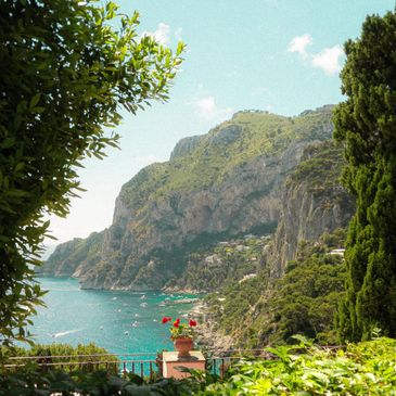Vista panoramica della costa rocciosa con mare e vegetazione verde.