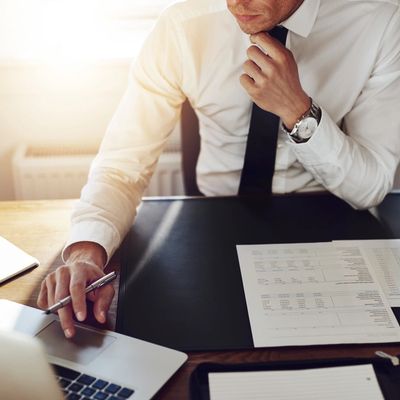 Businessman working at office with laptop and documents on his desk