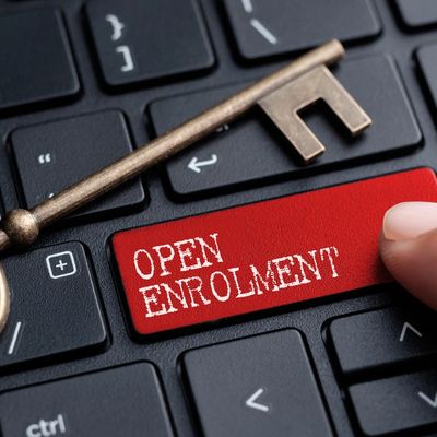 Closed up finger on keyboard with word OPEN ENROLLMENT