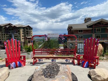 Two red Adirondack chairs and a red swing decorated patriotically at Park City Canyons Village.