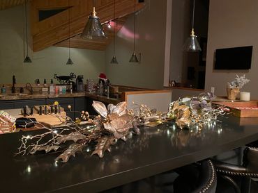 Decorative golden floral arrangement with lights on a black kitchen island.