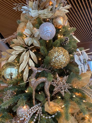 Close-up of an elegantly decorated Christmas tree with gold and white ornaments.