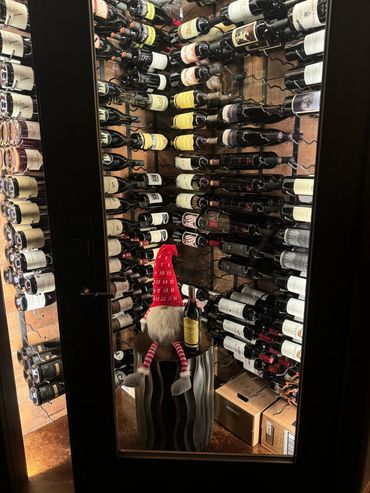A wine cellar with a festive gnome and a bottle of wine.