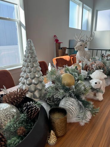Festive holiday decorations with reindeer, polar bear, and Christmas ornaments on a wooden table.