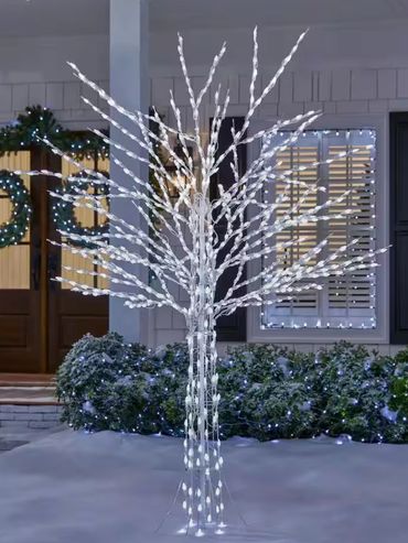 Decorative white LED light tree in a snowy front yard during winter.