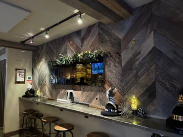 Bar counter with stools and New Year decorations on a rustic wooden wall.